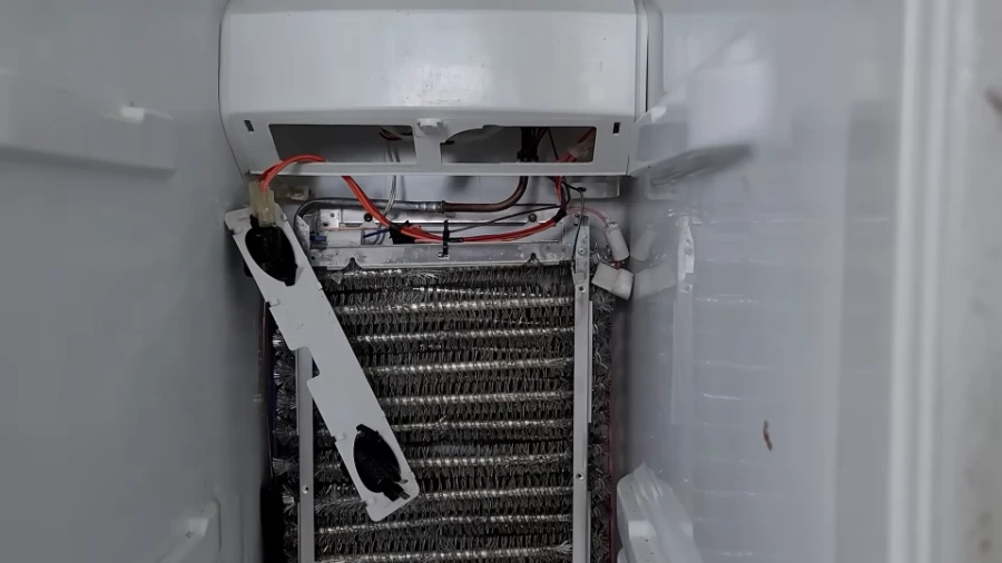 Heavy frost buildup on refrigerator evaporator coils caused by defrost system failure