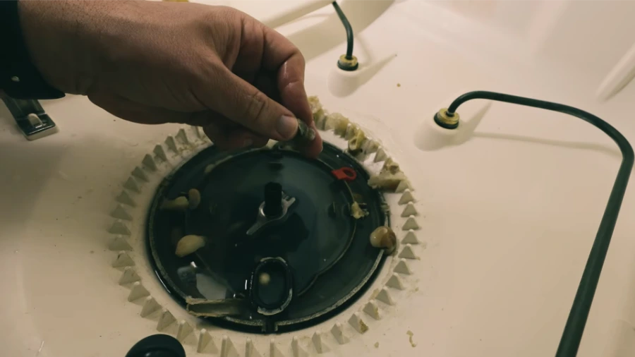 Dishwasher chopper blade assembly showing accumulated debris and wear