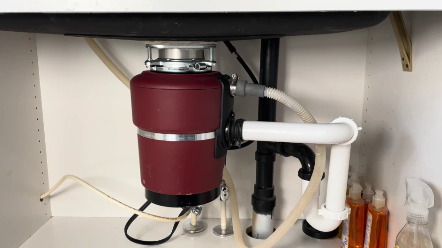 Dishwasher drain hose connection at garbage disposal showing high loop and air gap configuration