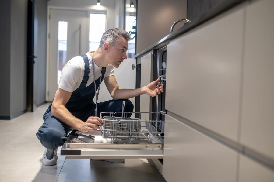 Dishwasher repair technician servicing a residential dishwasher in Concord NC