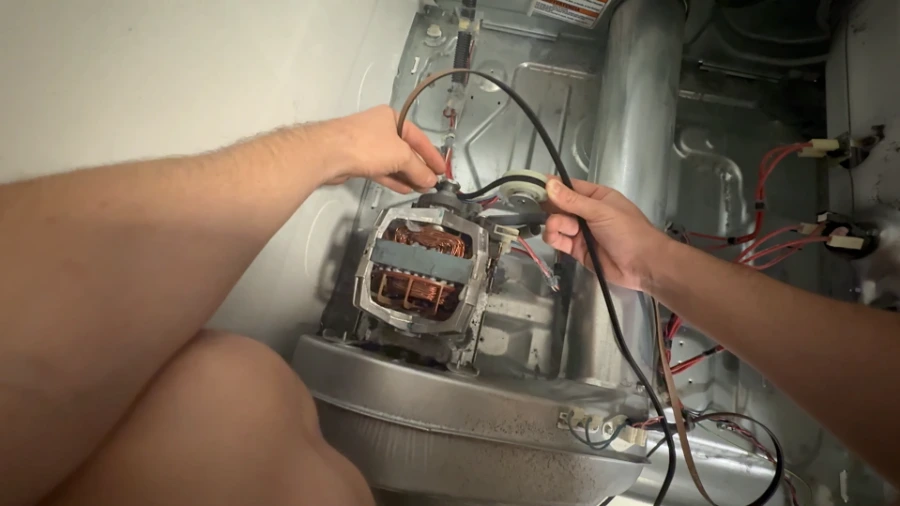 New dryer drive belt being installed around the drum