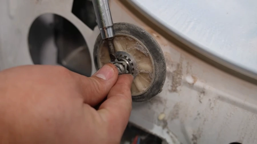 Worn dryer drum roller wheel being removed