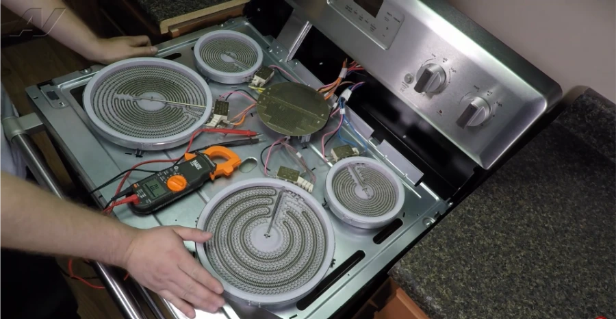Technician inspecting electric range surface burner components