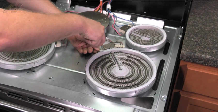 Technician replacing an electric range surface element