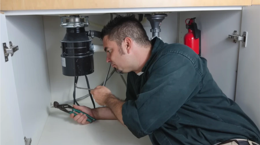 Technician diagnosing a garbage disposal problem