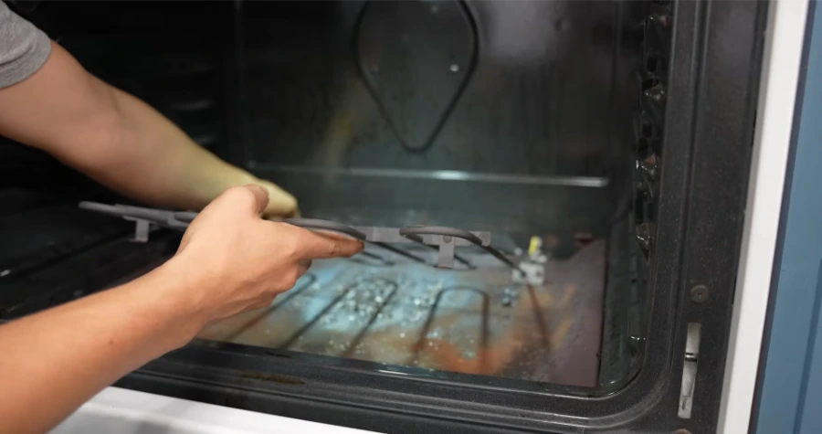 Technician removing a bake element from an electric oven