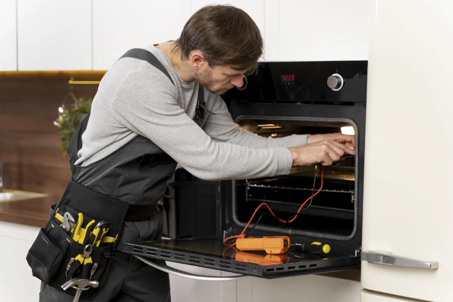 Technician servicing an oven and stove in a Concord, NC home