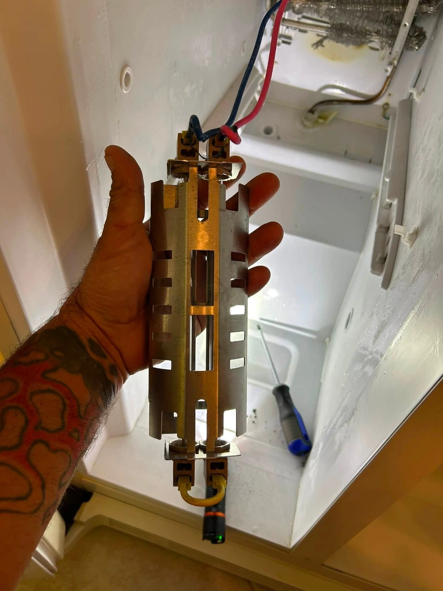 Refrigerator defrost heater removed from evaporator assembly during a service inspection